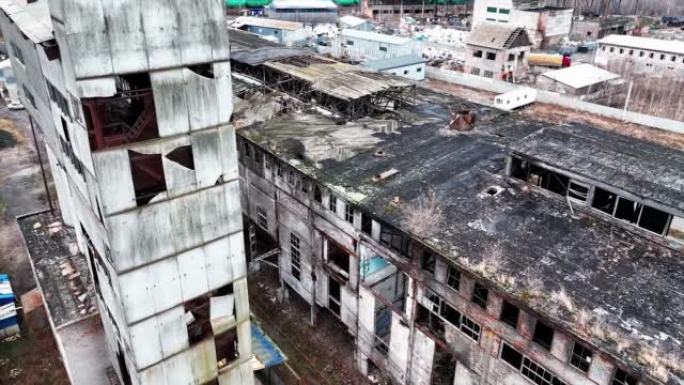 旧化工厂建筑群的外观腐烂。从空中角度看建筑物的灰色毁坏的墙壁和屋顶。