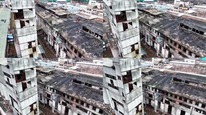 旧化工厂建筑群的外观腐烂。从空中角度看建筑物的灰色毁坏的墙壁和屋顶。