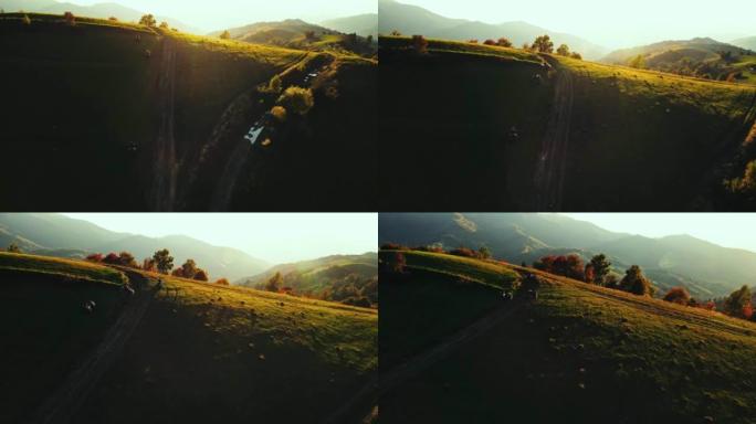 山里的日出。日落时在山脉上骑四轮摩托的人