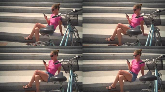 女孩用手机坐在楼梯上，骑自行车日出快速慢动作