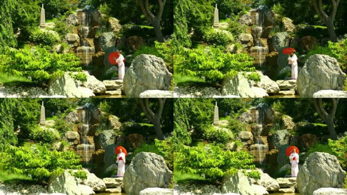 景观-一个穿着和服的女人在公园岩石中的瀑布附近的雨伞下