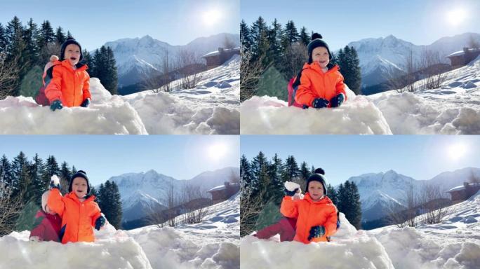 女婴坐在山上的雪堡垒里玩雪球