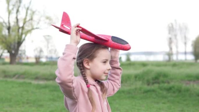 公园里的一个女孩玩玩具飞机，她想成为一名宇航员。梦想家飞行员。