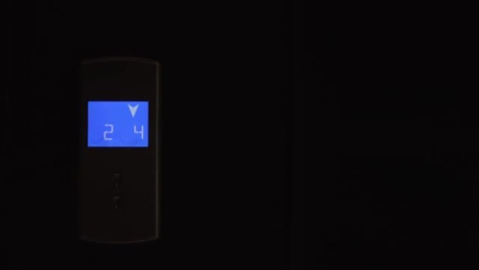 电梯上的蓝色液晶显示屏显示向下箭头，倒计时从7到2。