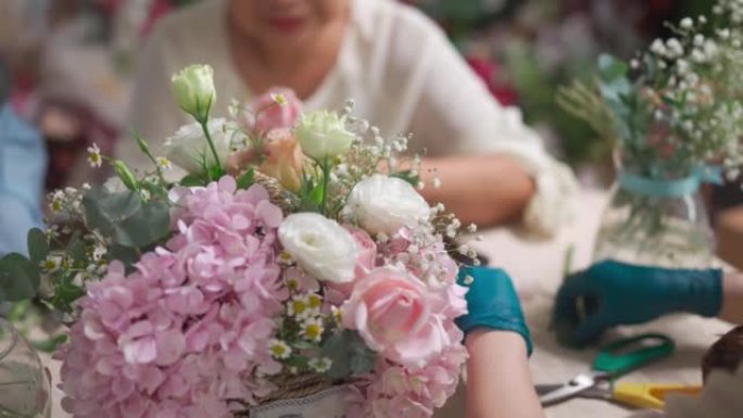 关闭亚洲中国女花店展示她的高级成人学生在花店插花