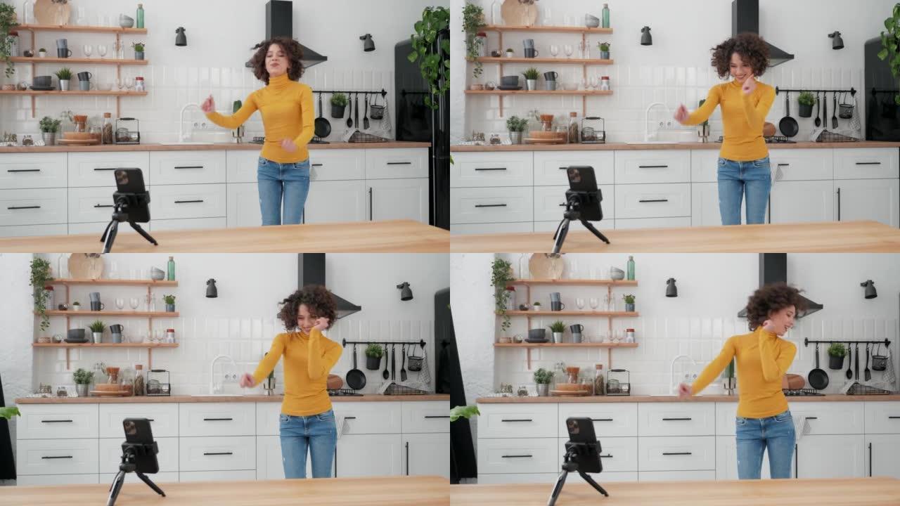 女人博主在智能手机摄像头上跳舞，为社交媒体录制视频