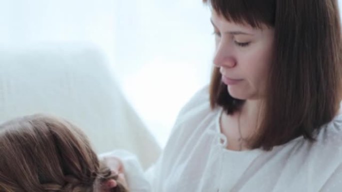 年轻母亲的肖像编织了女儿的头发。