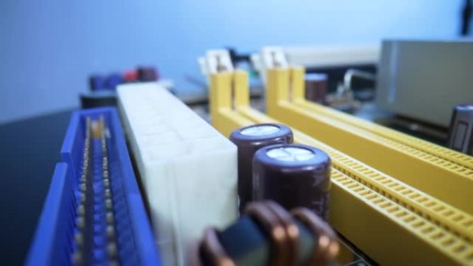 电脑主板微电路，带芯片、冷却用铝散热器、晶体管和电阻器。相机沿着黄色内存插槽滑动。主板电脑电路关闭