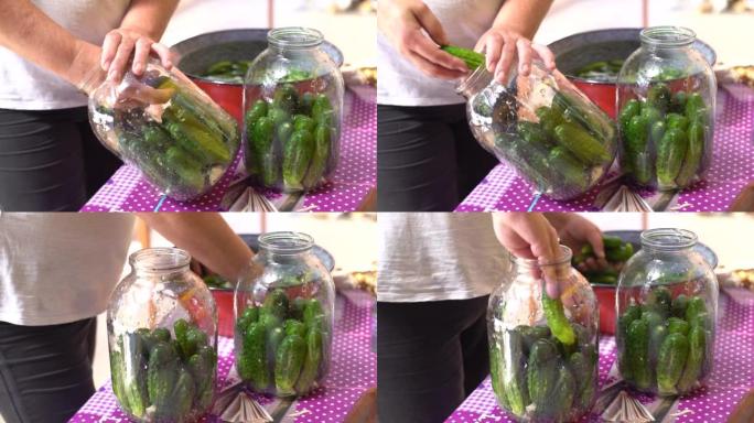女人在家里用玻璃罐装黄瓜过冬。蔬菜罐头。生态产品。