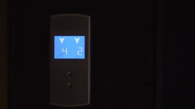 电梯蓝色照明的液晶显示器显示箭头和数字。