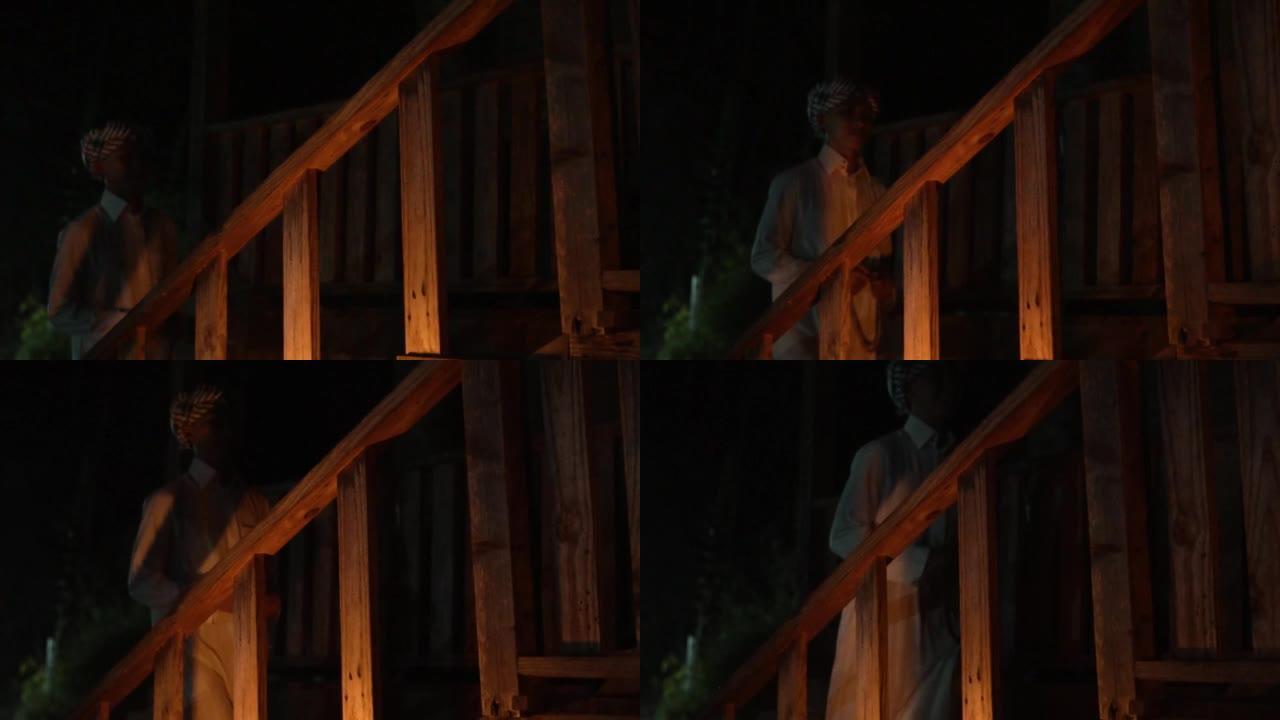 一名穆斯林男子穿着白色衣服穿过木制楼梯
