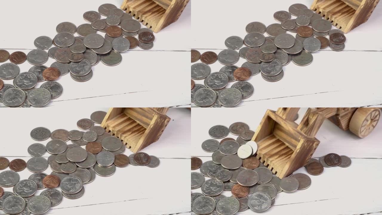 玩具拖拉机耙一堆美国美分，白色背景上的美国硬币并赚钱。