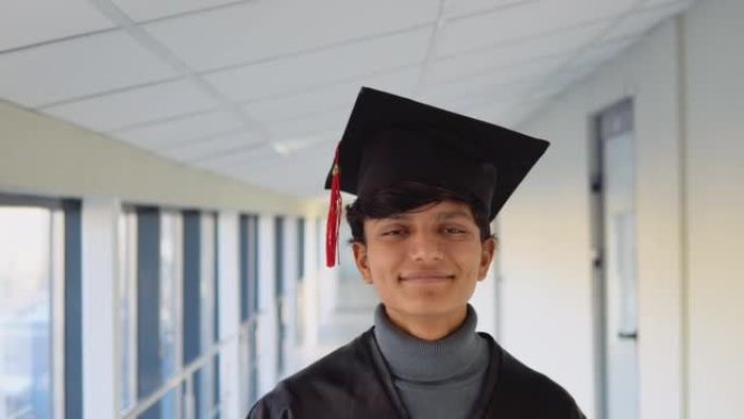 穿着黑色长袍，戴着大学硕士帽的印度毕业生的肖像。年轻专家