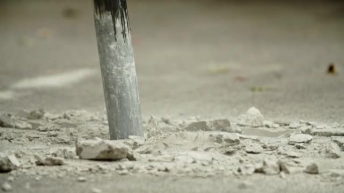 在混凝土路面上工作的挖掘机液压臂碎石机的特写