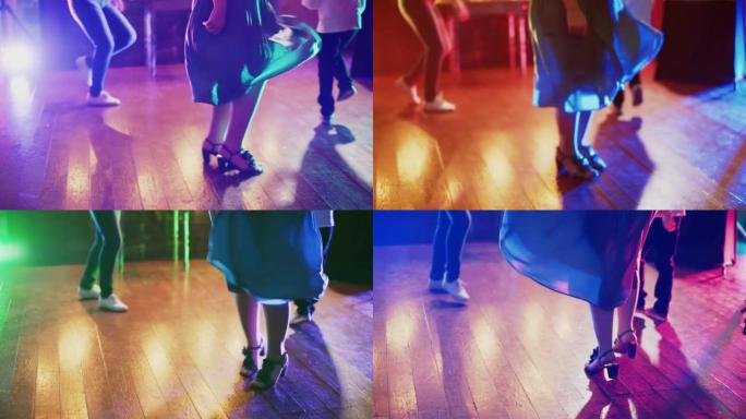 男人和女人的腿在灯光下在木地板上欢快地跳舞