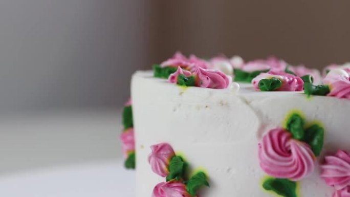 蛋糕与白色奶油和粉红玫瑰旋转特写，复制空间