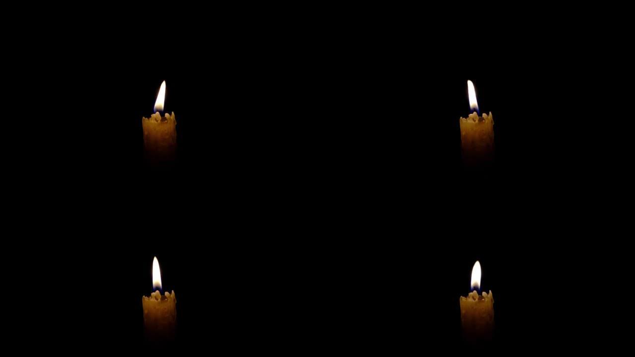 石蜡蜡烛在黑暗中燃烧，火焰明亮。