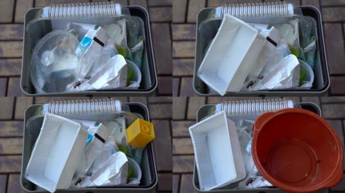 用于在家中单独收集塑料的篮子-将塑料食品容器中的废物扔进垃圾桶-拯救地球概念-走向绿色