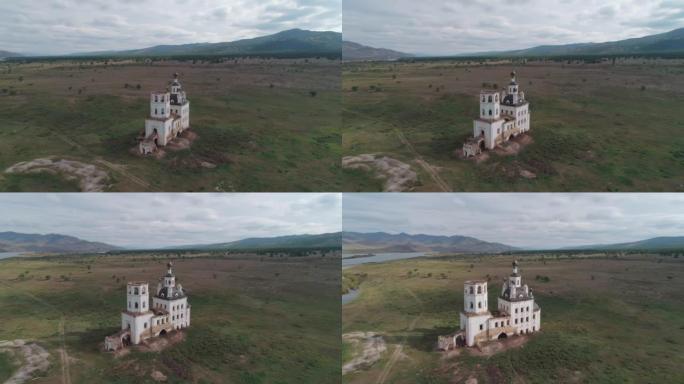 俄罗斯布里亚特共和国一座破旧教堂的鸟瞰图。被绿色草地和河流包围的教堂被毁