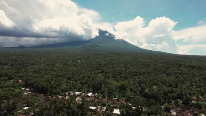 巴厘岛火山的空中射击，无人机射击，在稻田和梯田上向后飞行。多云的天空。