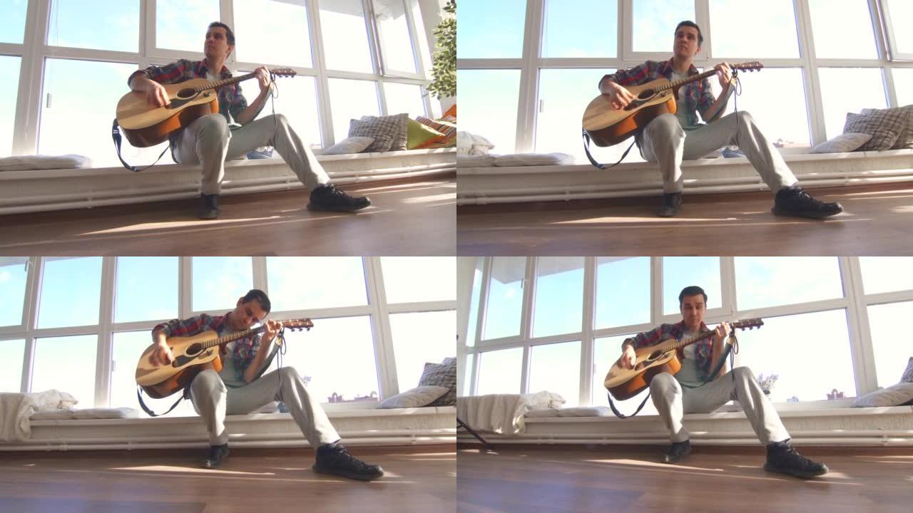 穿着衬衫的男吉他手在阳光明媚的房间里弹吉他