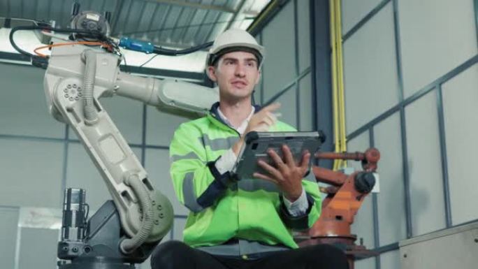 工程师合作男性检查机械臂系统与平板电脑笔记本电脑焊接在工业机械组件中的准备情况。