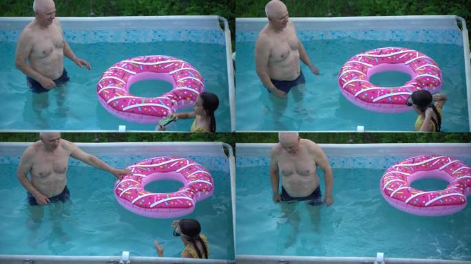 祖父和孙女在游泳池游泳