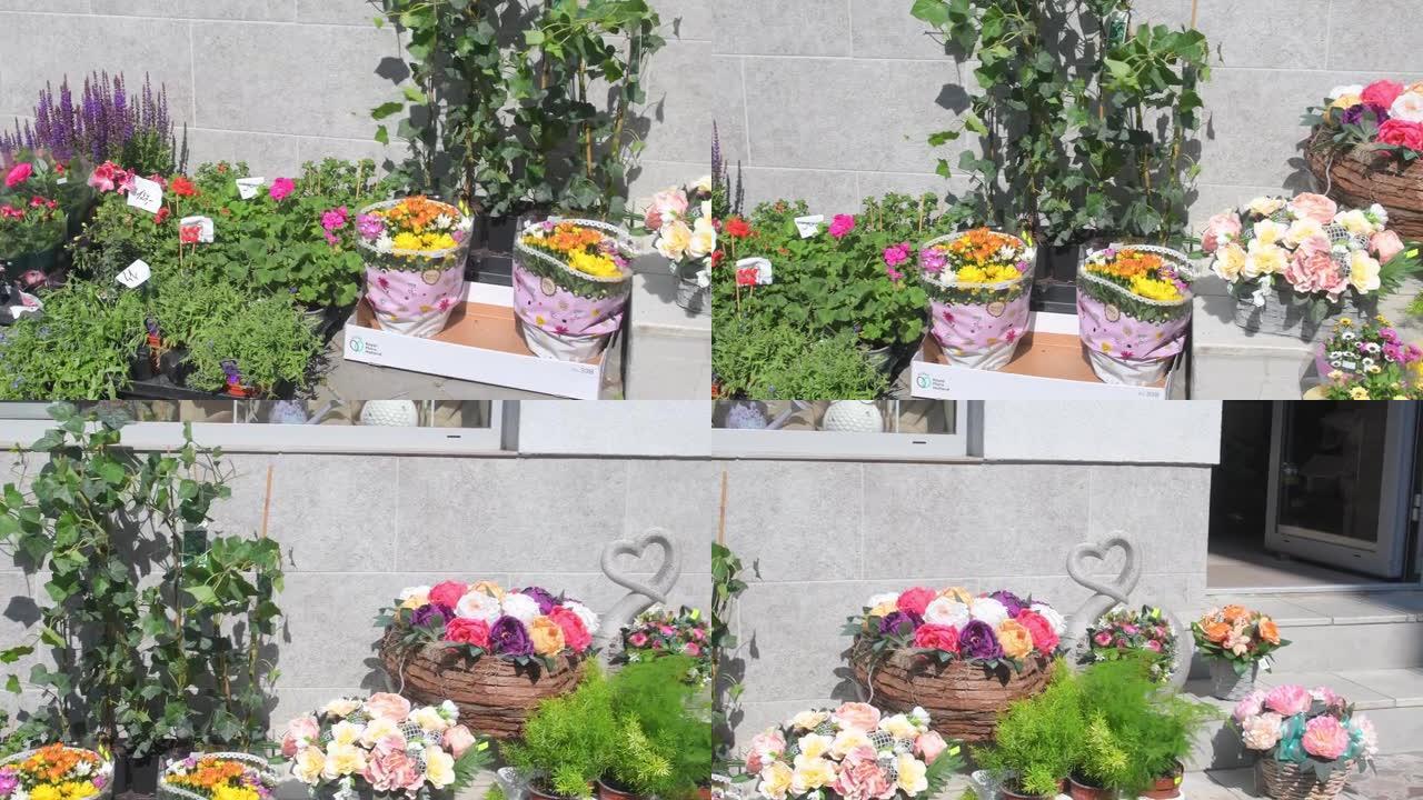 花店外部有插花和花束。鲜花准备在花店前出售。有植物和鲜花的花店的外观。小花店前的鲜花和家居装饰。欧洲