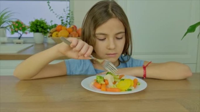 这孩子吃煮菜。选择性聚焦。食品。