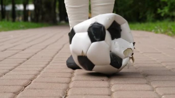 破碎的泄了气的足球落在前面女孩的鞋上，慢动作