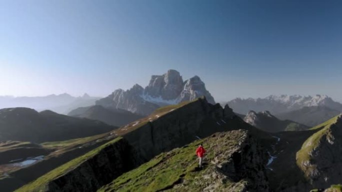 穿着红色夹克的徒步旅行者在意大利多洛米蒂山脊上行走