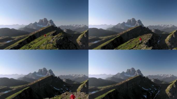 穿着红色夹克的徒步旅行者在意大利多洛米蒂山脊上行走