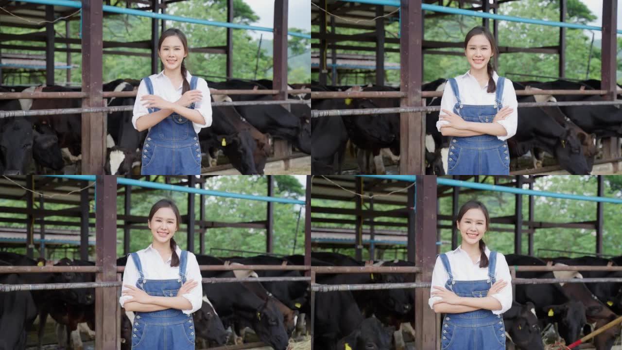迷人的亚洲奶农妇女在农场户外工作的肖像。年轻美丽的女孩农业农民在畜牧业中快乐地检查田间的奶牛动物，看