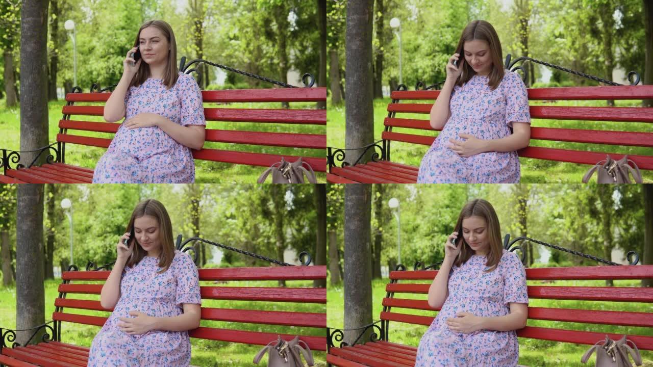 与医生的远程会诊。一名孕妇坐在夏季公园里用手机聊天
