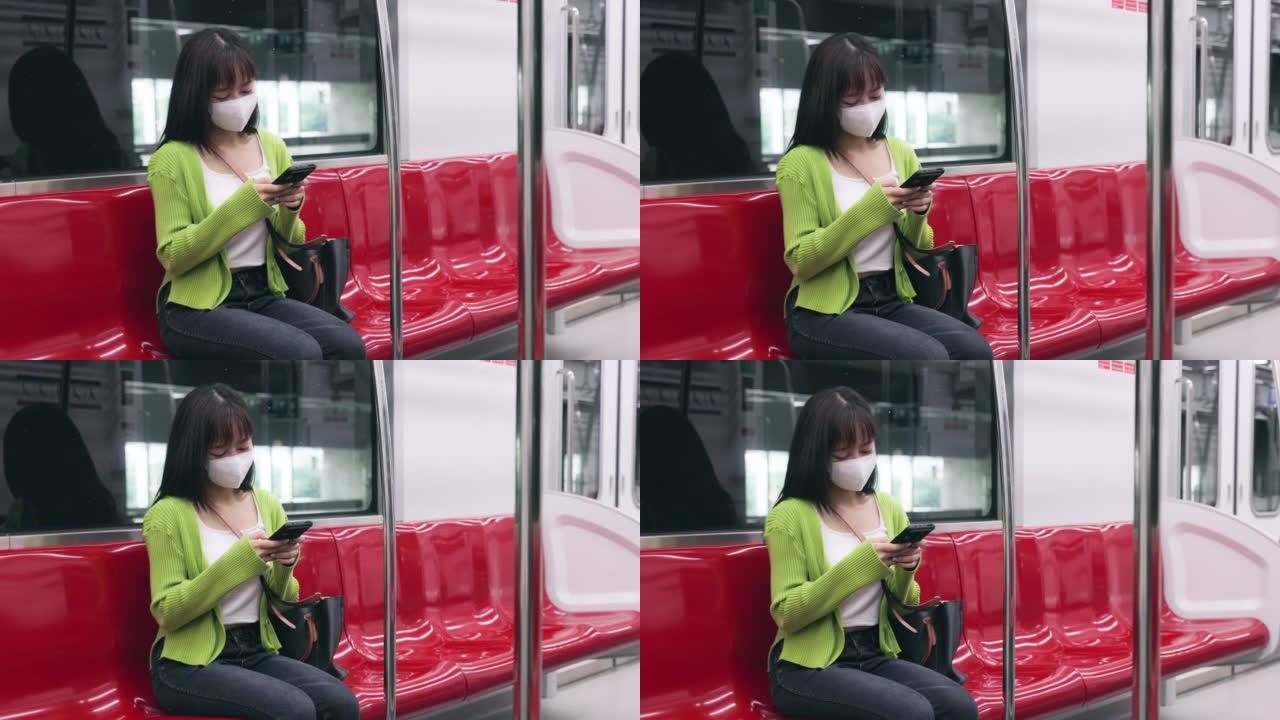 年轻的亚洲妇女在通勤时在移动银行上阅读交易中的电子邮件在火车上工作。
