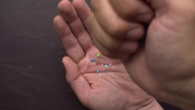 落在人手中的微型塑料颗粒的特写镜头。