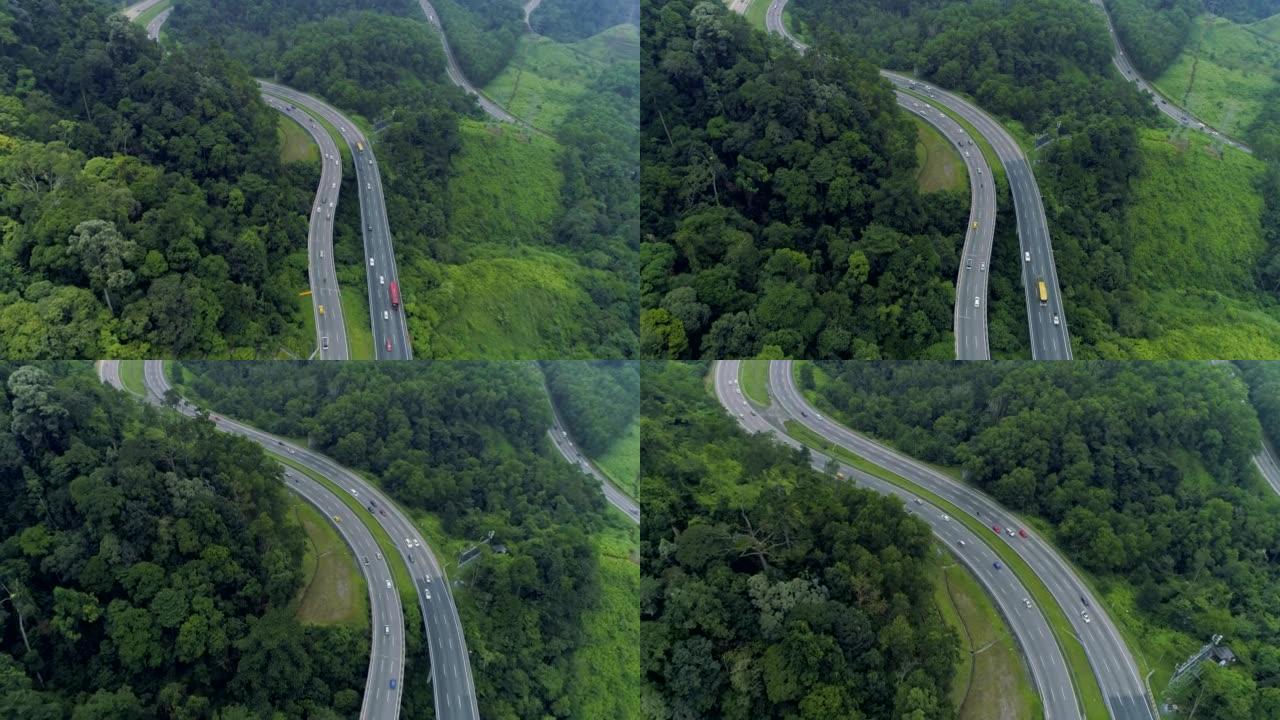 绿色森林4k之间有迎面而来的两条高速公路的鸟瞰图