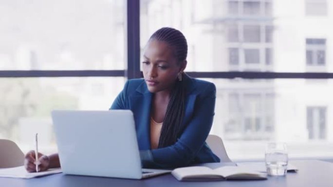 专注的女商人键入电子邮件，在她的文档上写下想法。非裔美国女商人正在阅读有关其无线设备规划想法的电子邮