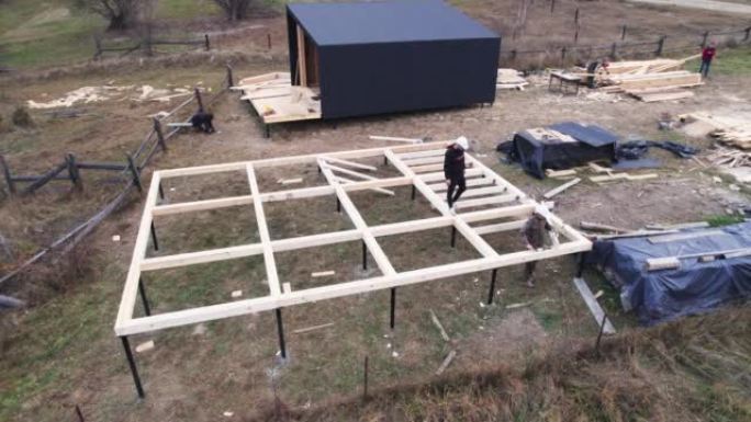 工人在桩基上建造木结构房屋。
