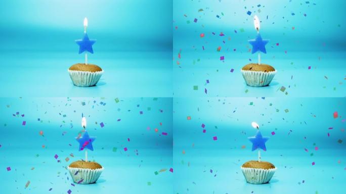 节日烘焙纸杯蛋糕，蓝色背景上有一支燃烧的星星形状的蜡烛。点燃新鲜的蛋糕上。