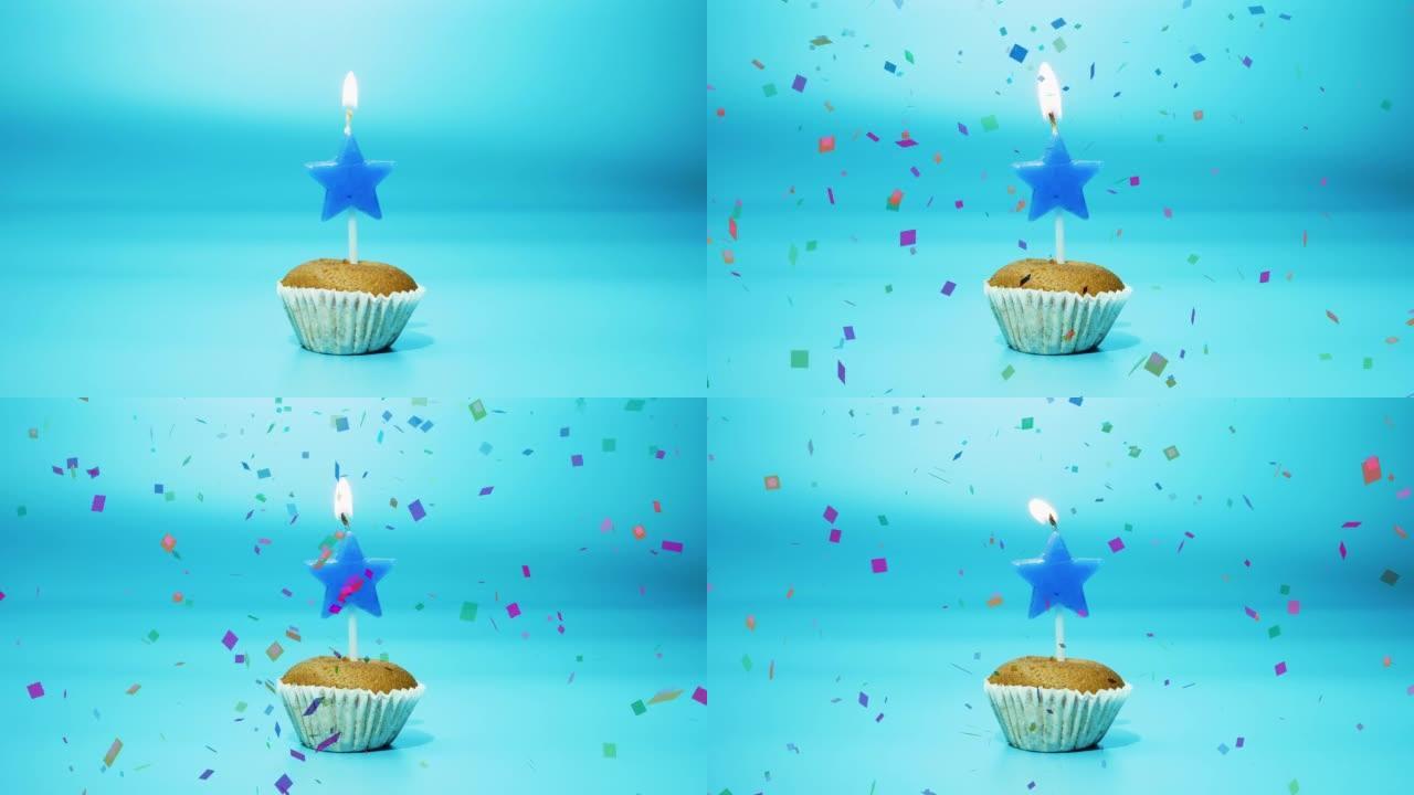 节日烘焙纸杯蛋糕，蓝色背景上有一支燃烧的星星形状的蜡烛。点燃新鲜的蛋糕上。