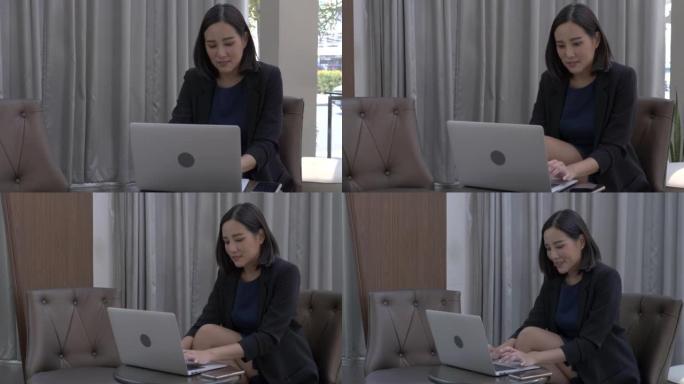 在明亮的休息区使用笔记本电脑的亚洲商业女性
