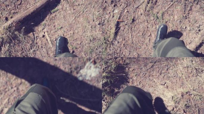 俯视图穿着军鞋的男性在森林的地面上向前移动。缓慢的运动。