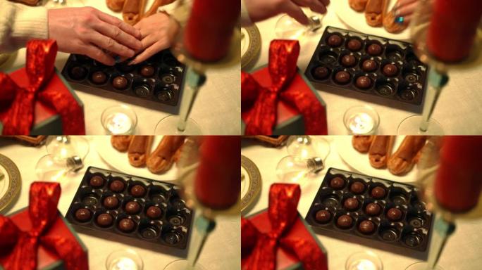 高角度看糖果在桌子上，男性和女性的手触摸着甜点。无法辨认的高加索夫妇在室内约会。浪漫和团结的概念。