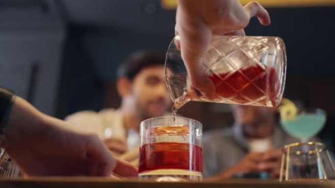 4k男性酒保在豪华酒吧的吧台为顾客准备鸡尾酒饮料。