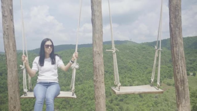 女人在山顶上旅行时玩家用秋千