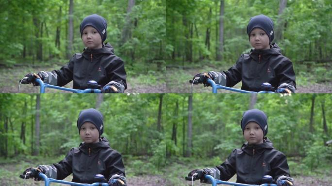 一个严肃的白人男孩在森林里骑自行车的肖像。