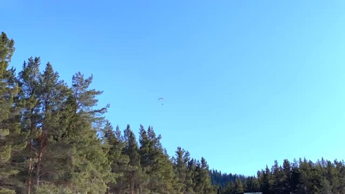 在吉尔吉斯斯坦卡拉卡乌山滑雪基地上空滑翔伞。远射。