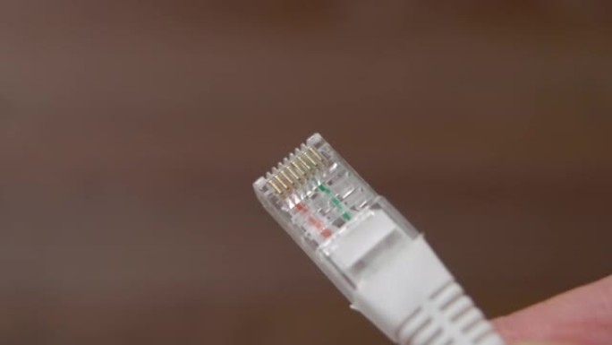 网络电缆插头近在咫尺。以太网连接设备。棕色背景上的网线