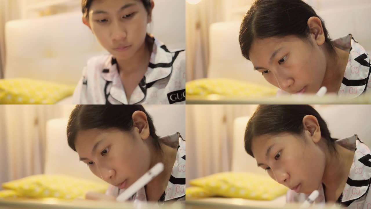 亚洲女孩使用数字平板电脑和铅笔在日本折叠桌上做作业时，晚上在家，生活方式理念。